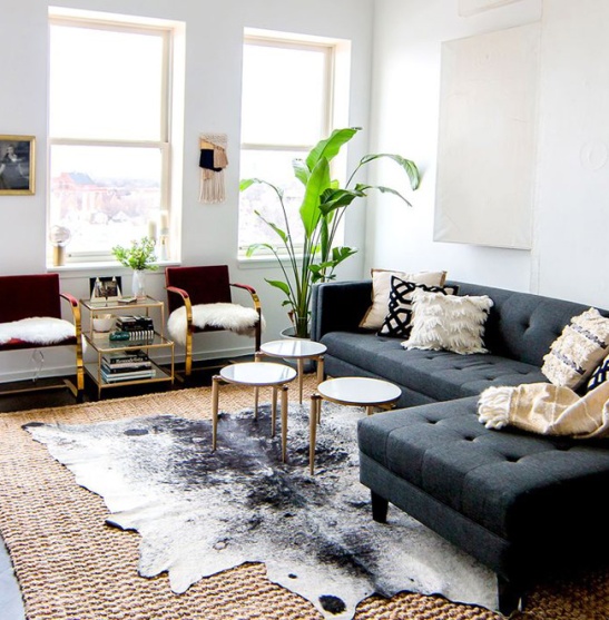 layering-rugs-cowhide-over-seagrass-living-room-Shelby-Girard-via-Domaine-1